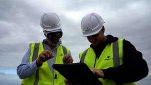 Two construction workers on-site, one using a VR headset to visualise the project using generative AI